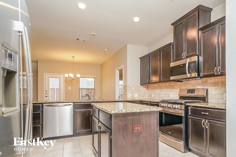 A kitchen with a stainless steel refrigerator and oven.