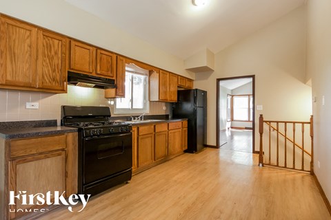 A kitchen with wooden cabinets and black appliances.