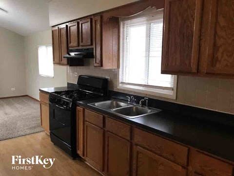 A kitchen with wooden cabinets and black appliances.