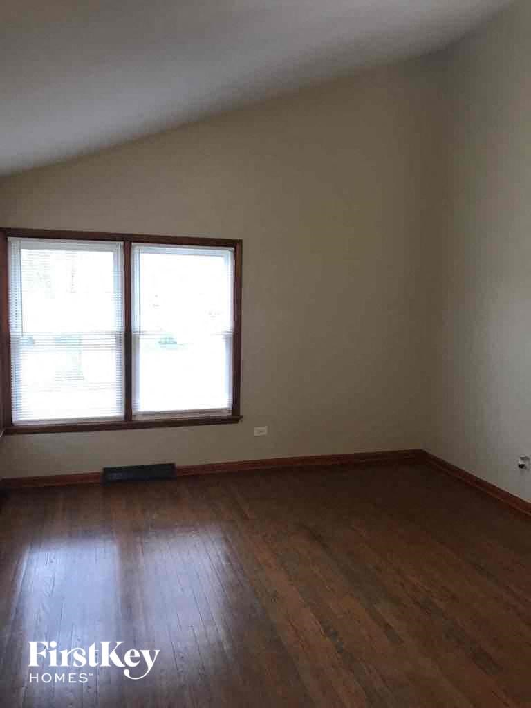 A room with wooden floors and two windows.