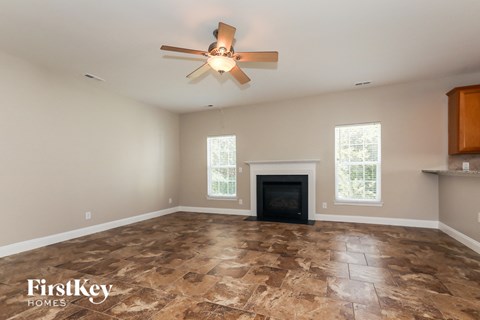 a living room with a fireplace and a ceiling fan