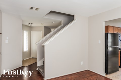 A kitchen with a refrigerator and a staircase.