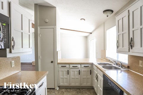 A kitchen with white cabinets and a sink.