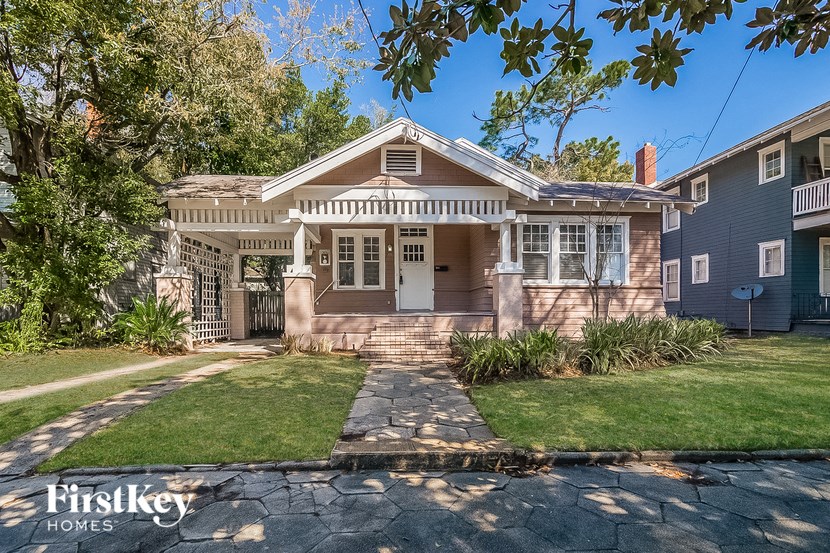 the front of a house with a walkway and grass
