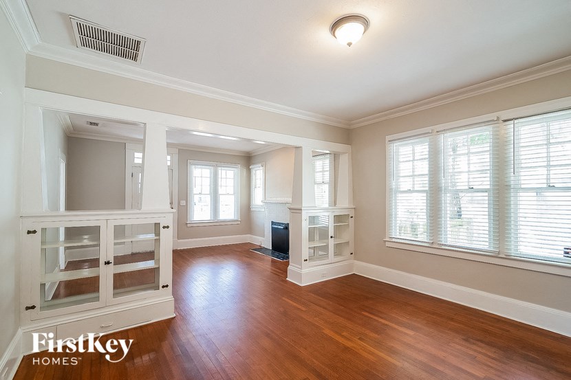 an empty living room with a hard wood floor and windows