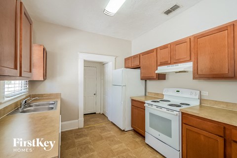 a kitchen with white appliances and wooden cabinets