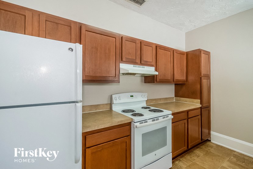 a kitchen with a white stove and a refrigerator