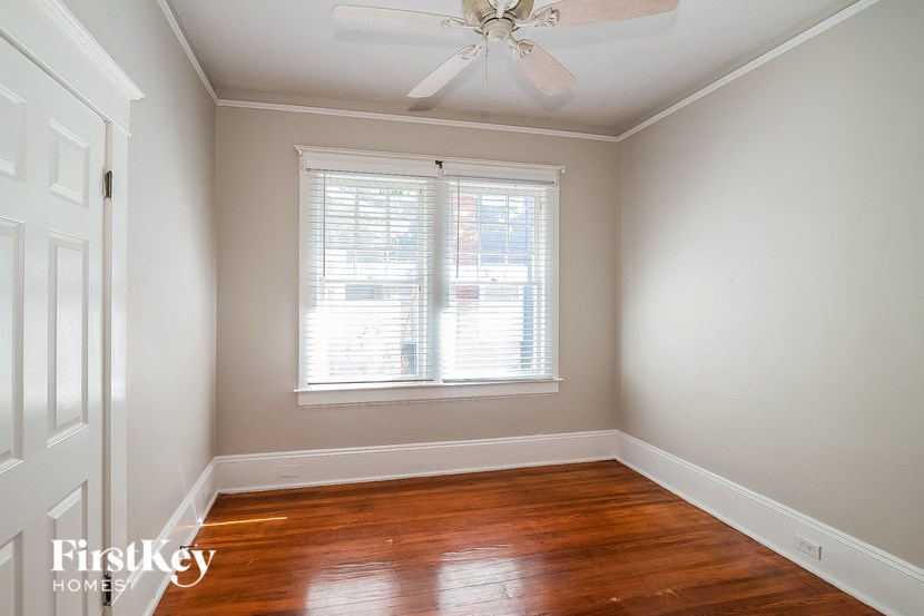 a empty room with a ceiling fan and a window