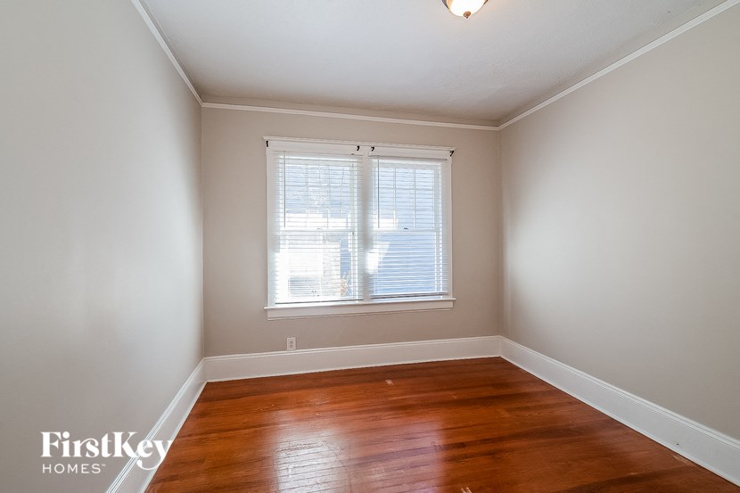 a empty room with a window and wooden floors