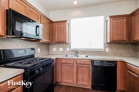 A kitchen with wooden cabinets and black appliances.