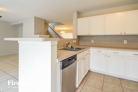 A kitchen with white cabinets and a stainless steel dishwasher.
