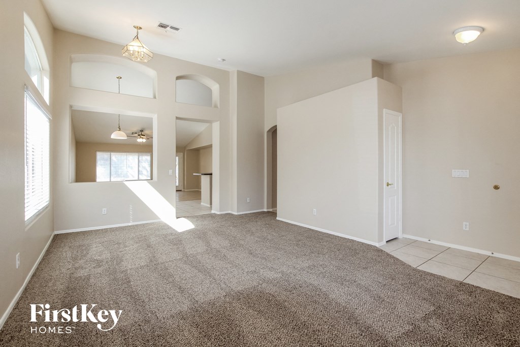 an empty living room with carpet and white walls