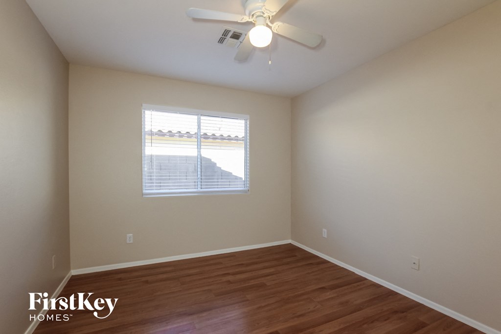 a bedroom with a ceiling fan and a window