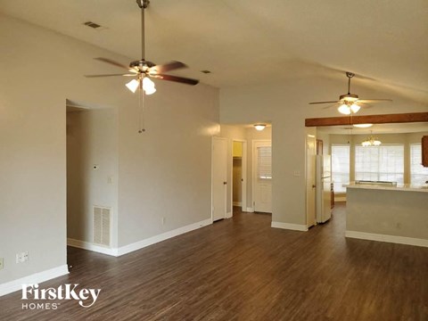 an empty living room with a ceiling fan