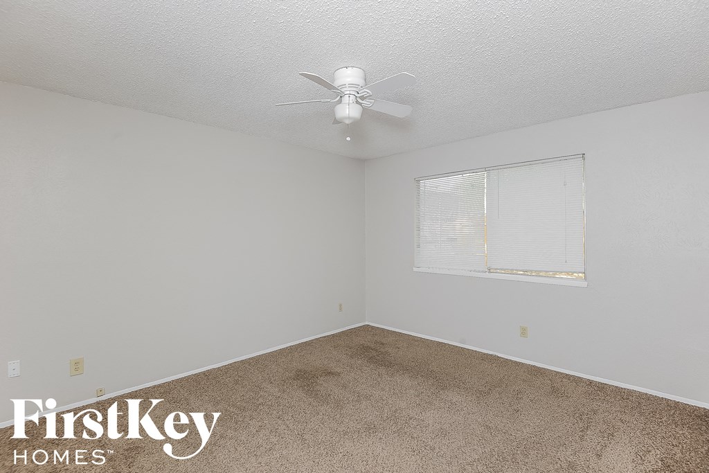 a bedroom with a ceiling fan and a window