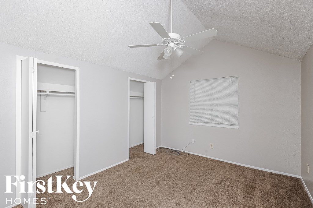a bedroom with a ceiling fan and a closet