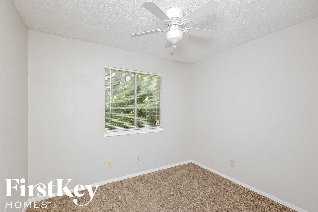 a bedroom with a ceiling fan and a window