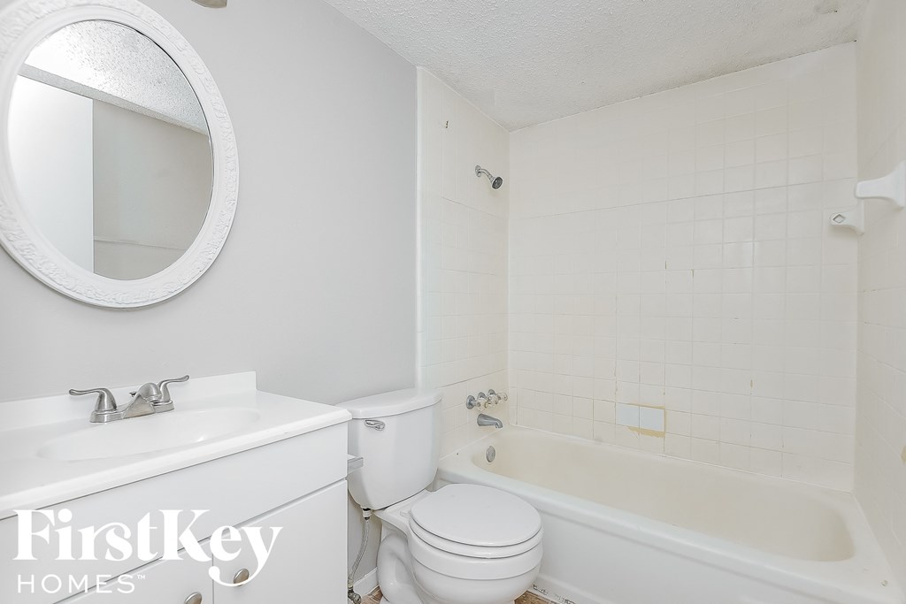 a white bathroom with a white toilet and a tub and a sink