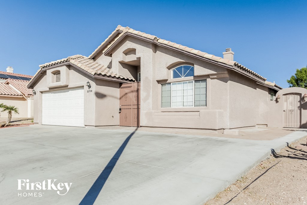 A house with a garage and a driveway in front of it.