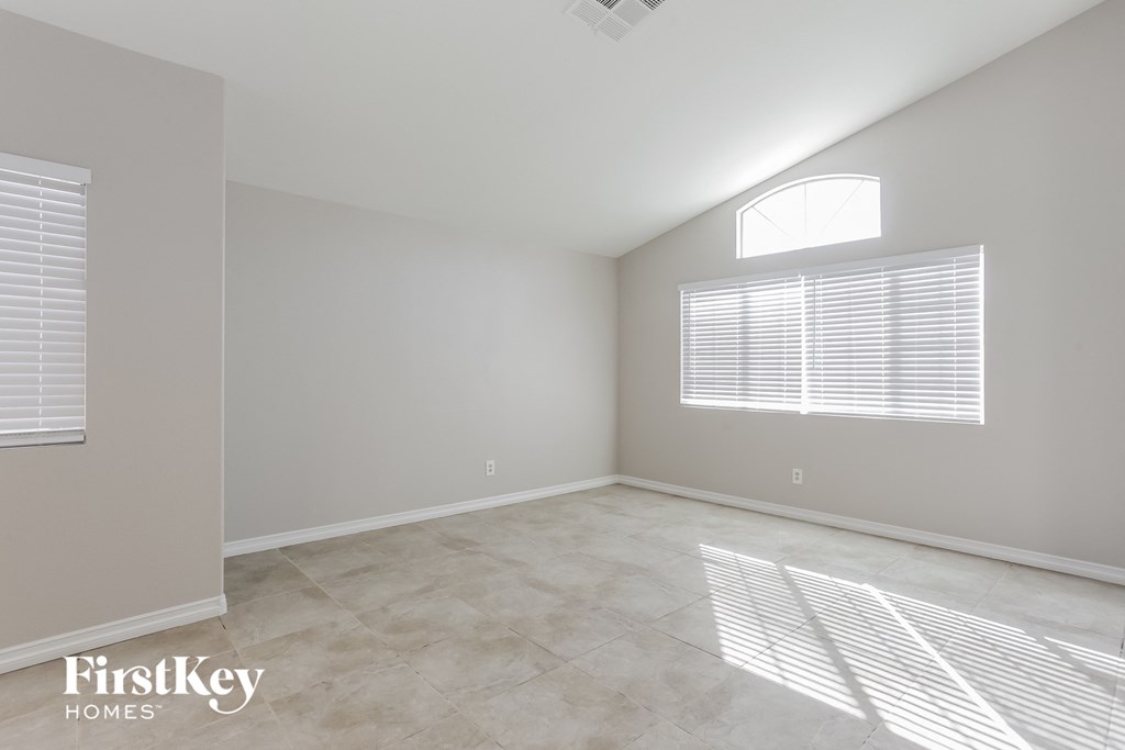 A sunny room with a window and a tiled floor.