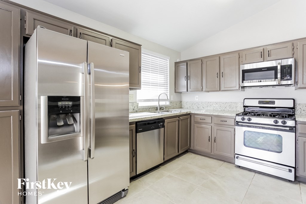 A kitchen with a stainless steel refrigerator and oven.