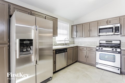 A kitchen with a stainless steel refrigerator and oven.