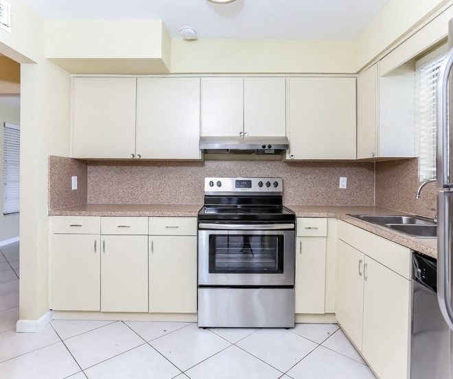 a kitchen with white cabinets and a stove and a sink