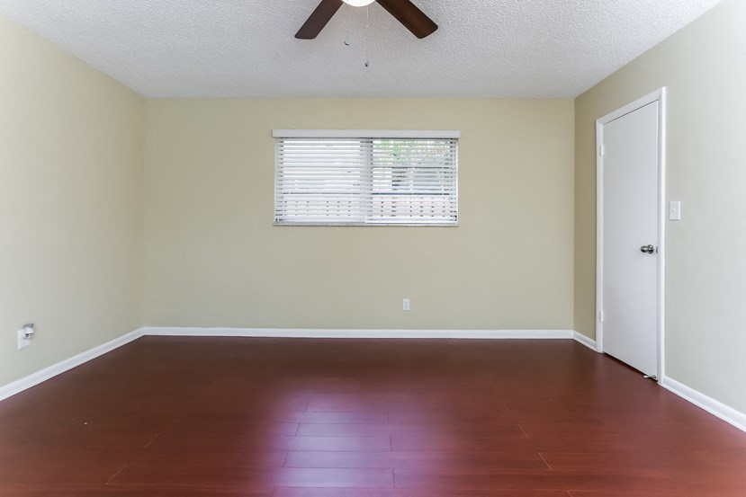 a empty room with wood floors and a window