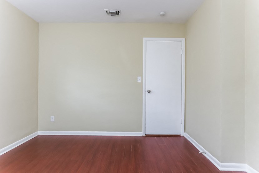 an empty room with a wooden floor and a white door