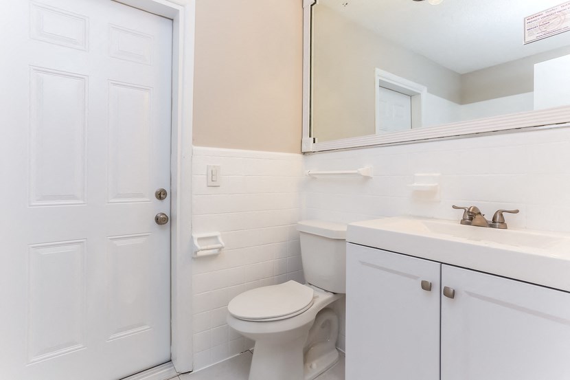 a bathroom with a toilet sink and a mirror