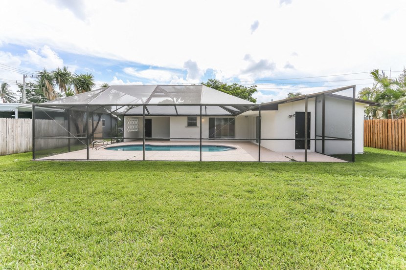 a backyard with a pool and a glass house