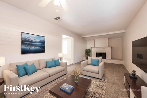 A living room with a couch, a coffee table, and a painting on the wall.