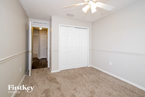 a bedroom with a white door and a ceiling fan