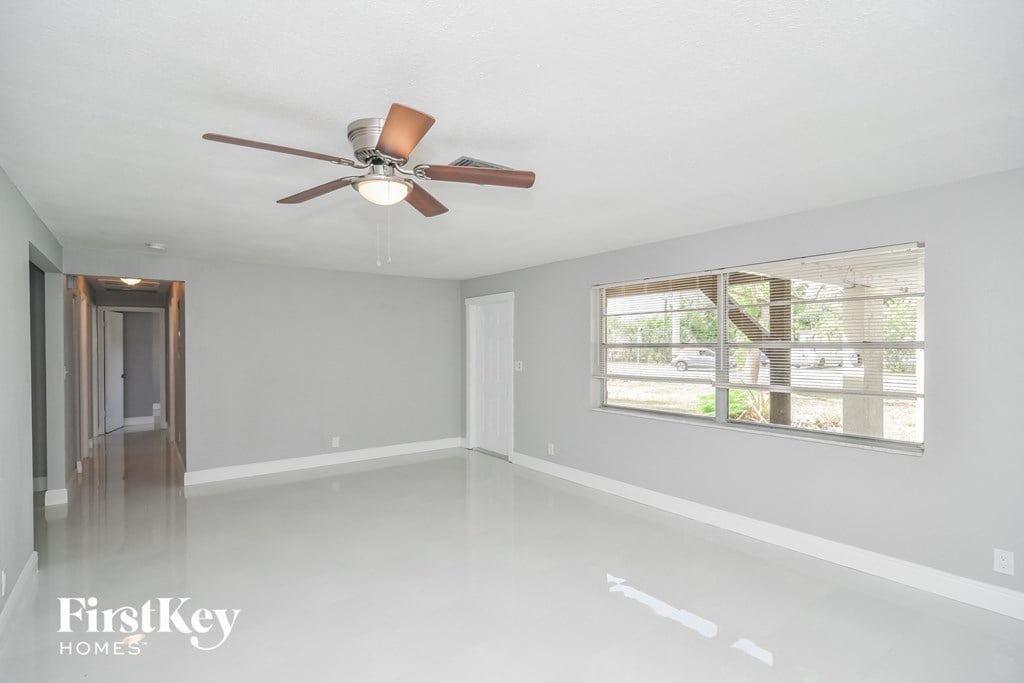 a empty living room with a ceiling fan and a large window