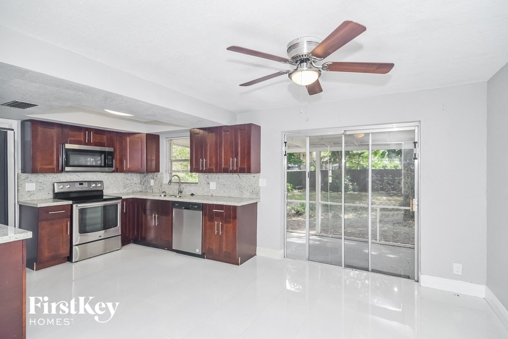 a kitchen with wooden cabinets and stainless steel appliances and a ceiling fan