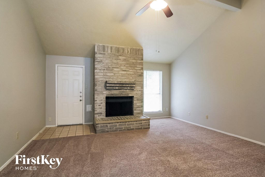 the living room of an empty house with a fireplace