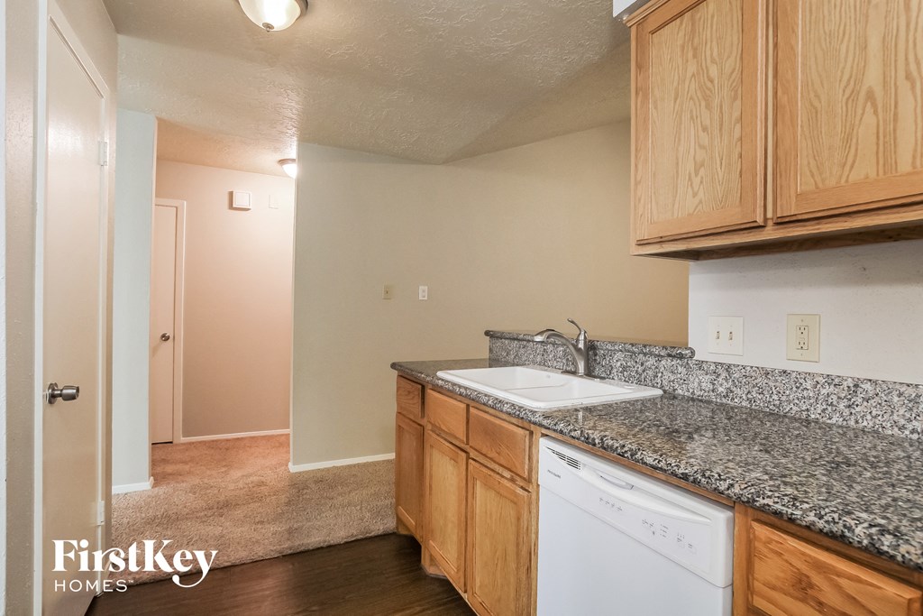 a kitchen with granite countertops and a white dishwasher