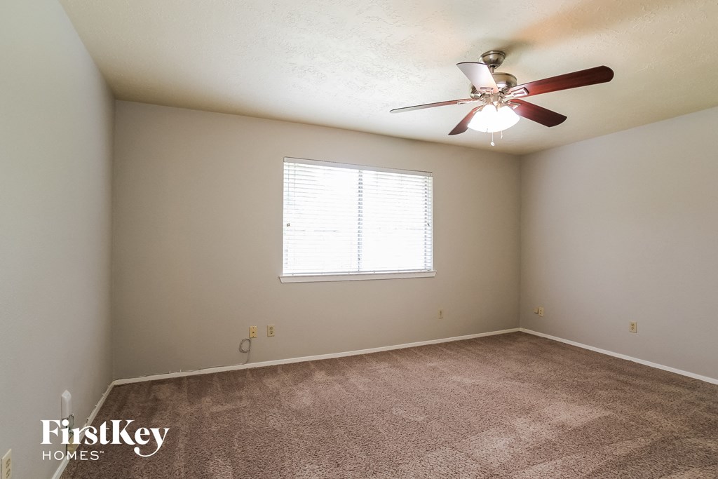 a bedroom with carpet and a ceiling fan
