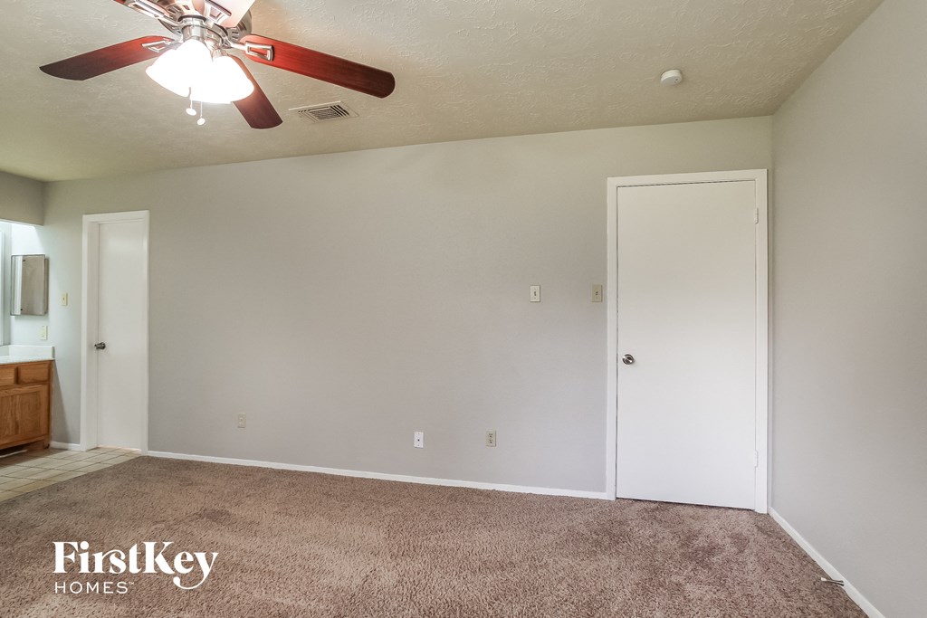 the living room of an empty house with a ceiling fan