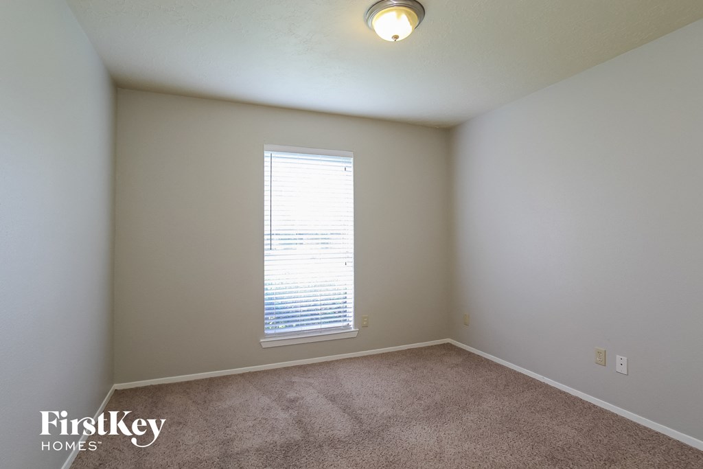 a bedroom with a carpeted floor and a large window