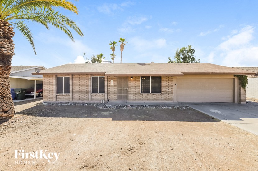 a brick house with a garage and palm trees