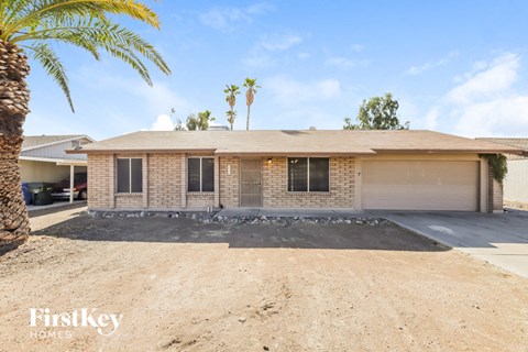 a brick house with a garage and palm trees
