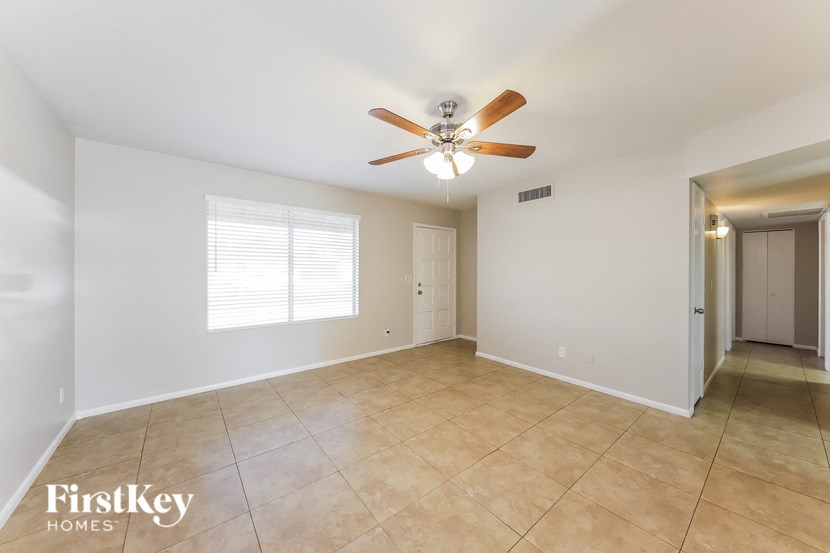a living room with a ceiling fan and a tiled floor