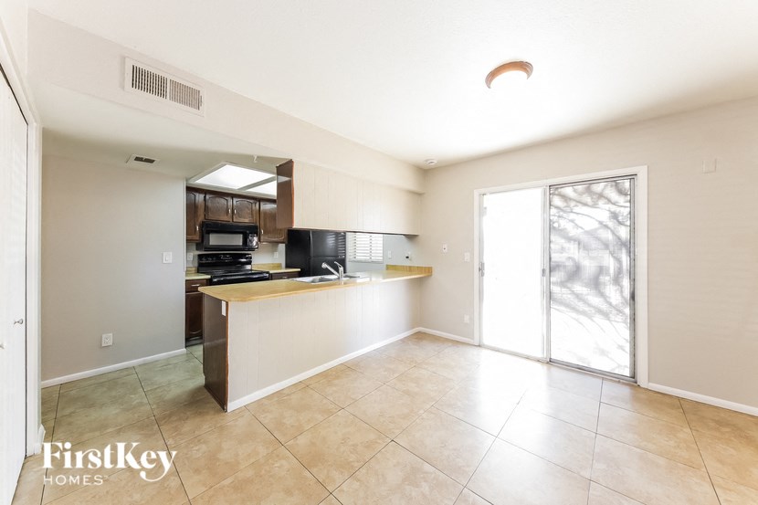 an open kitchen and living room with a sliding glass door to the patio