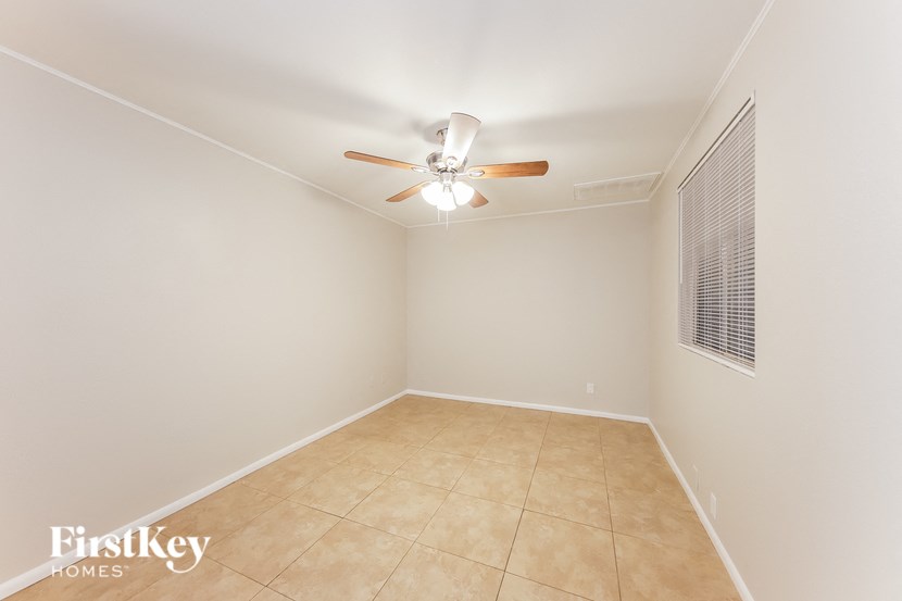 a empty room with a ceiling fan and a tiled floor