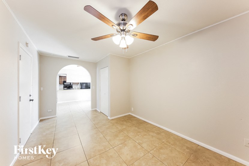 a living room with a ceiling fan and a tiled floor