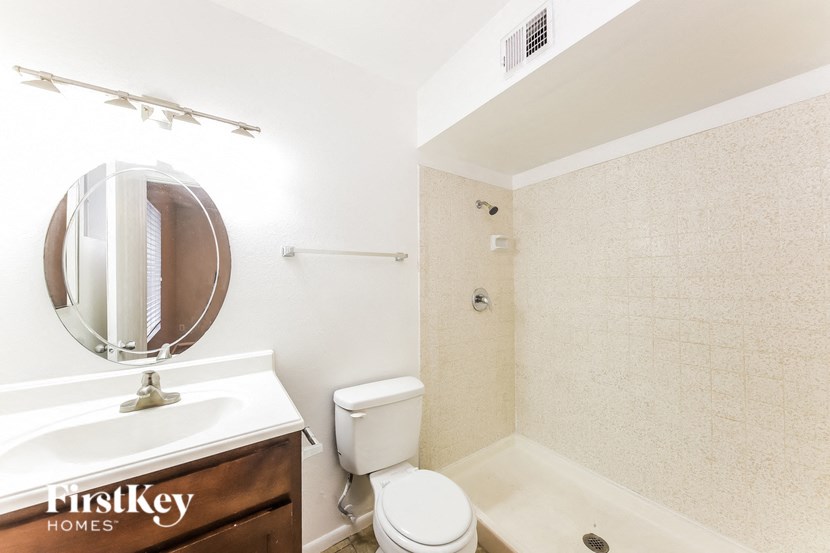 a bathroom with a toilet and a sink and a mirror