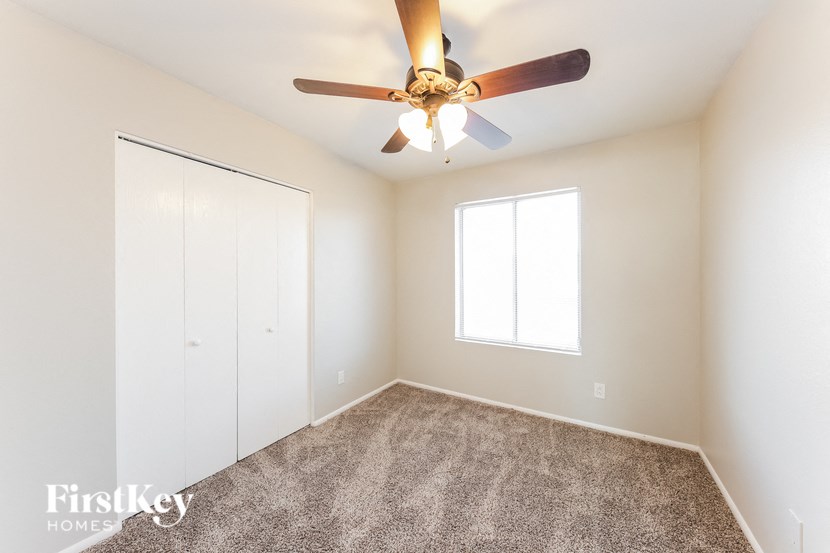 a bedroom with a ceiling fan and a closet