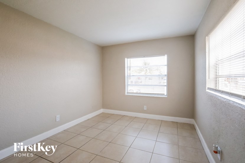 A room with a window and tiled floor.