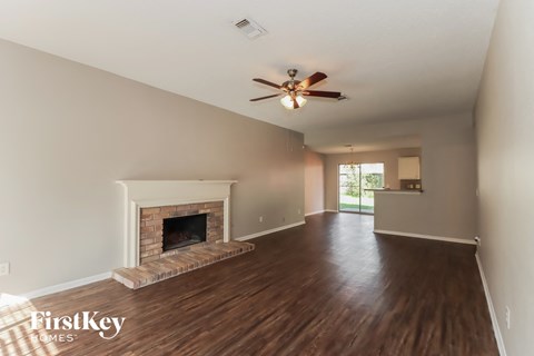a living room with a fireplace and a ceiling fan